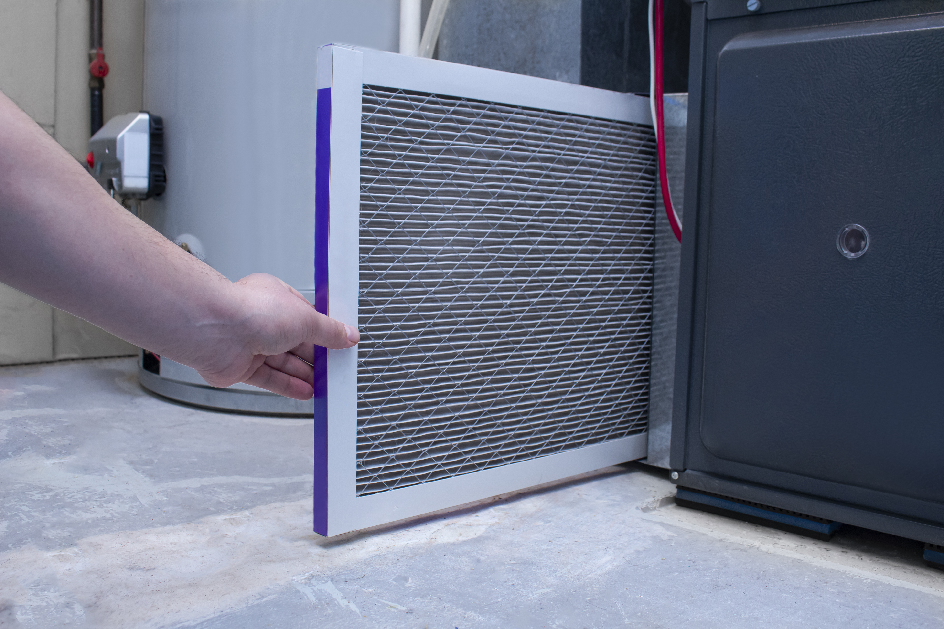 A clean HVAC filter being installed.