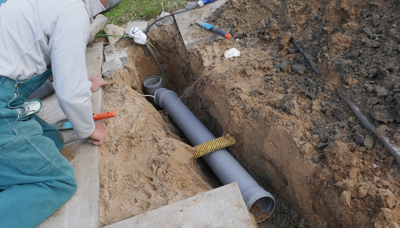 A worker fixing a sewer line