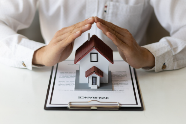 Man's hands sheltering home insurance papers - does home insurance cover HVAC?
